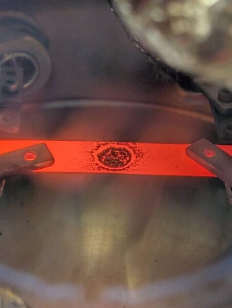 研究の際に、真空蒸着装置で試料を加熱している様子